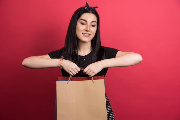 Woman showing her bags on red background - Foto, afbeelding