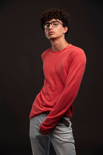 Jong model in rood shirt poserend in gietstukken. Hoge kwaliteit foto - Foto, afbeelding