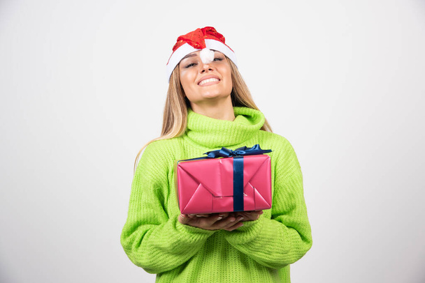 Young smiling woman holding a festive Christmas present. High quality photo - Photo, Image
