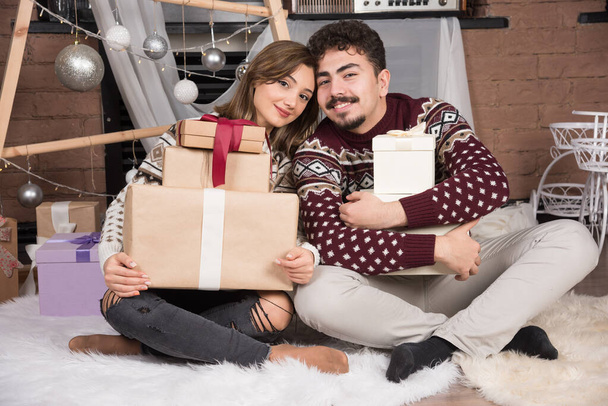 Young couple sitting on the floor in Christmas interior. High quality photo - Foto, Imagem