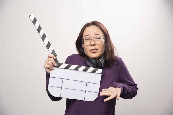 Young woman holding a cinema tape on a white background . High quality photo - Photo, Image