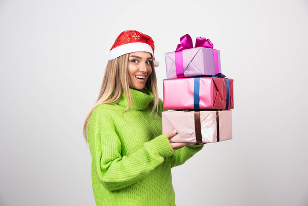 Junge Frau mit vielen festlichen Weihnachtsgeschenken. Hochwertiges Foto - Foto, Bild