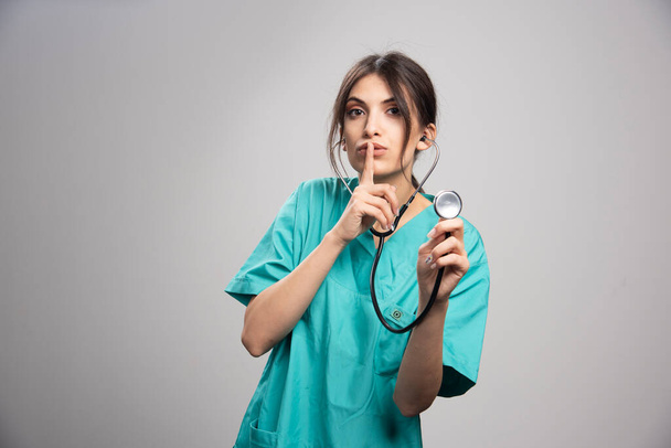 Πορτραίτο γυναίκας γιατρού με στηθοσκόπιο σε γκρι φόντο. Υψηλής ποιότητας φωτογραφία - Φωτογραφία, εικόνα