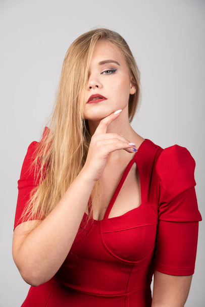 Blonde woman in red outfit posing to camera. High quality photo - Photo, Image