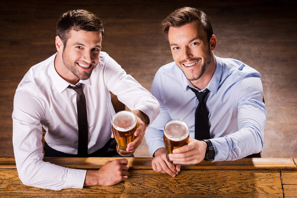 Men in shirt and tie holding glasses with beer - Fotó, kép