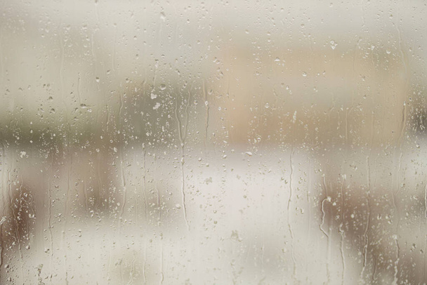 Nahaufnahme von Regentropfen mit Schnee auf einer Fensterscheibe. Schweden. - Foto, Bild