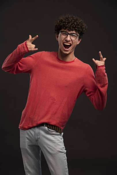 Young model in red shirt posing in castings screaming. High quality photo - 写真・画像