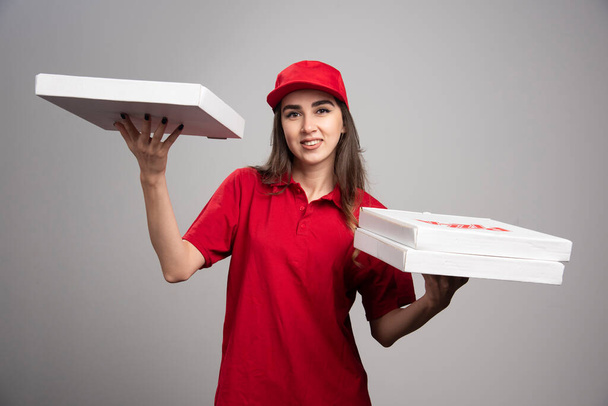Bezorgster poseert met pizza bestellingen. Hoge kwaliteit foto - Foto, afbeelding