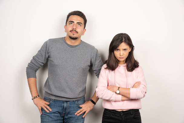 Young couple is mad at each other standing on white background. High quality photo - Photo, Image