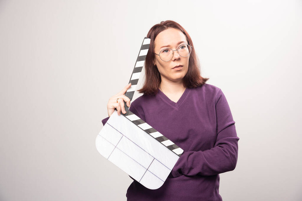 Young woman posing with a cinema tape on a white background . High quality photo - Foto, Imagen