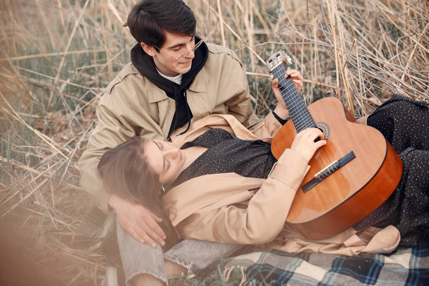 Beautiful couple spend time in a autumn field - Fotoğraf, Görsel