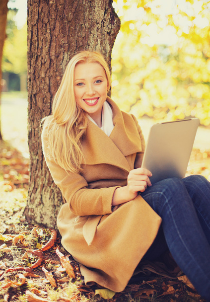woman with tablet pc in autumn park - Fotó, kép