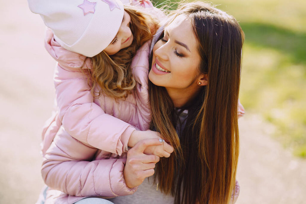 Mother with daughter playing in a spring park - Foto, imagen