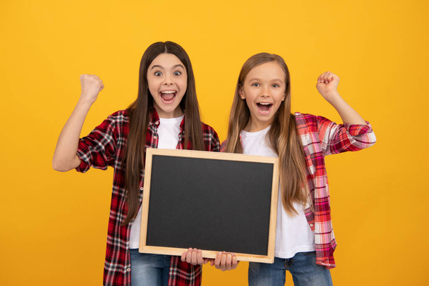 enfants heureux dans casual à carreaux tenir tableau noir de l'école pour l'espace de copie, succès - Photo, image