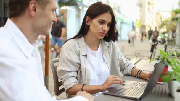 Nuori viehättävä nainen liiketapaamisessa ystävien kanssa nauraa puhua istuu ulkona kahvilassa. hidastettuna lähikuva - Materiaali, video