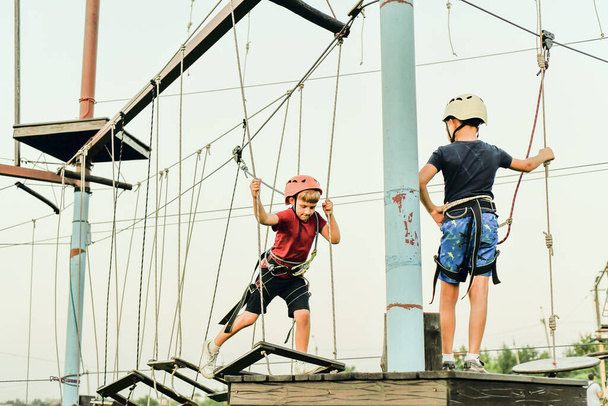Dois meninos em uma estrada de corda em um parque extremo de esportes. - Foto, Imagem