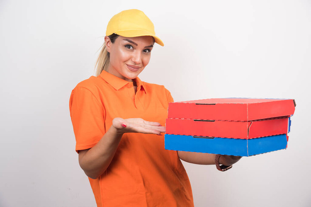 Beyaz arka planda pizza kutusu tutan sarışın teslimatçı kadın. Yüksek kalite fotoğraf - Fotoğraf, Görsel