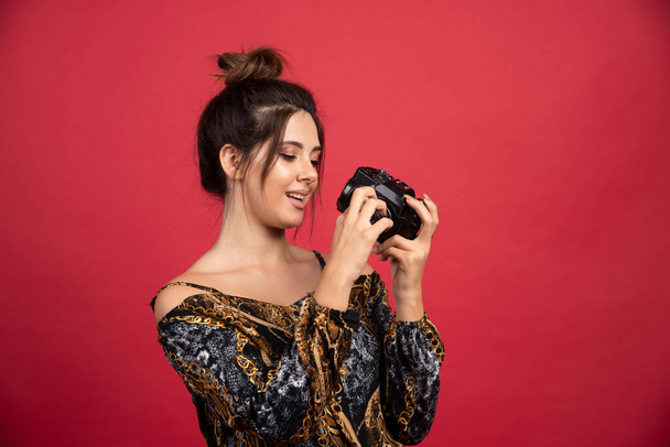Brunette girl holding a professional dslr camera and thinking. High quality photo - Fotoğraf, Görsel