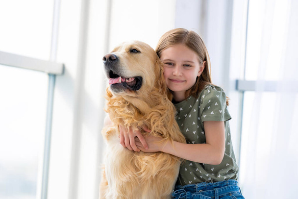 Child girl with golden retriever dog - Фото, зображення