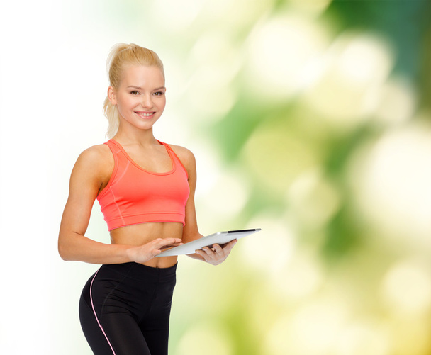 smiling sporty woman with tablet pc computer - Фото, зображення