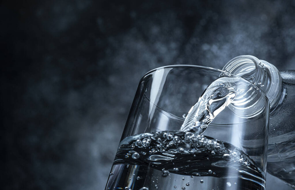 Pouring water on black background with copy space - Photo, Image
