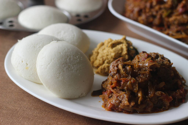 Höyrytetty riisikakku tunnetaan yleisesti nimellä Idly Intiassa on yksi terveellisimmistä aamiaistuotteista intialaisessa keittiössä. Tarjoillaan Kerala tyyliin mausteinen lampaan paistettua ja kuivaa kookospähkinää chutney. - Valokuva, kuva