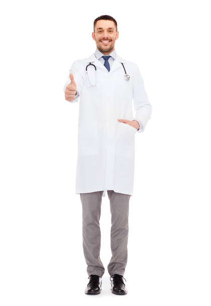 smiling doctor with stethoscope showing thumbs up - Foto, afbeelding