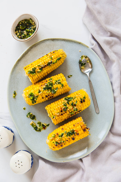 Corn grilled with salt and spices. Light background. Fast food in the summer. - Foto, afbeelding