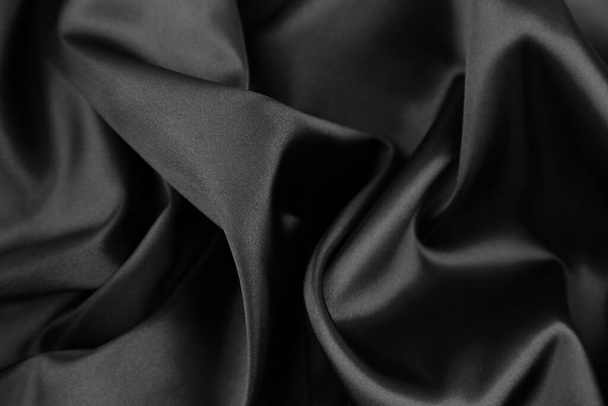 Closeup of rippled black silk fabric - 写真・画像