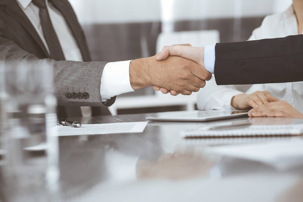 Handshake as successful negotiation ending, close-up. Unknown business people shaking hands after contract signing in modern office - Fotó, kép