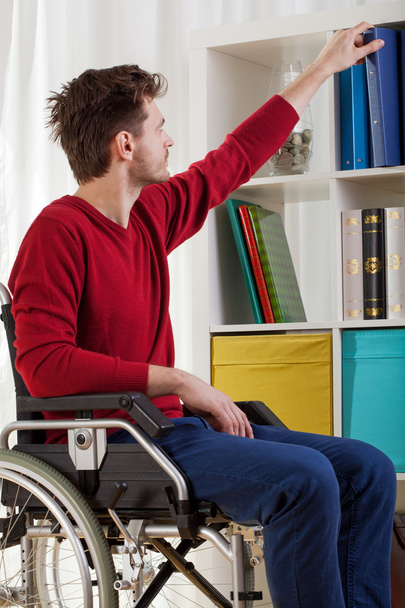 Disabled man taking book  - 写真・画像