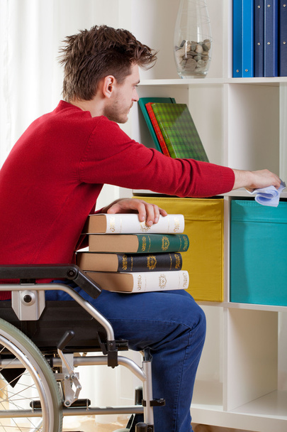 Disabled holding a book and wiped the dust - Foto, afbeelding