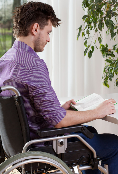 Capable disabled man reading a book - Foto, afbeelding
