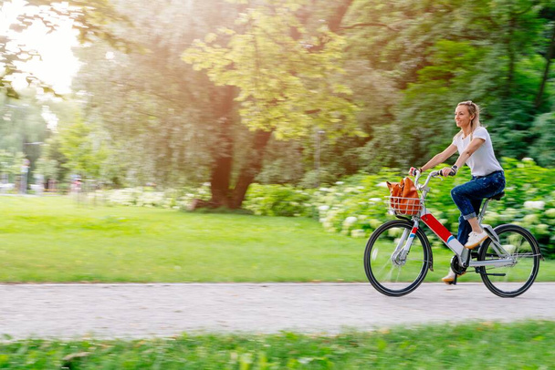 Hermosa y alegre mujer adulta disfrutar de paseo en bicicleta en la actividad de ocio urbano al aire libre soleado en la ciudad. - Foto, Imagen