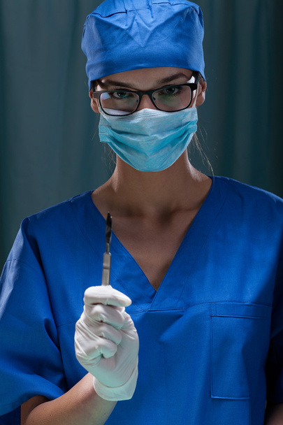 Portrait of a female surgeon holding surgical scalpel - Foto, imagen