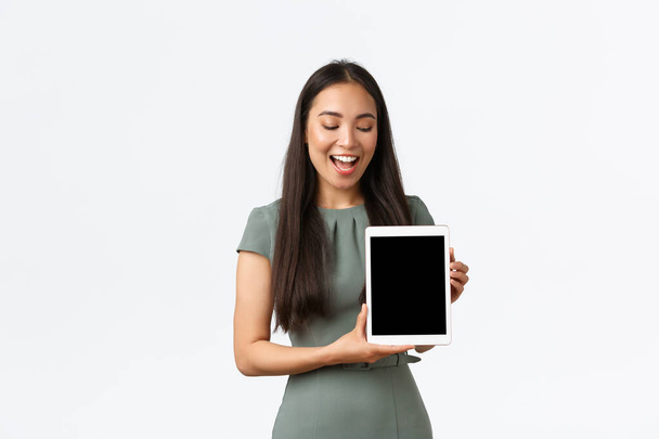Kisvállalkozások tulajdonosai, startup és munka otthonról. Boldog vidám ázsiai nő, hogy annak érdekében, online áruház, mutató link vagy alkalmazás, nézi a digitális tablet képernyő mosollyal - Fotó, kép