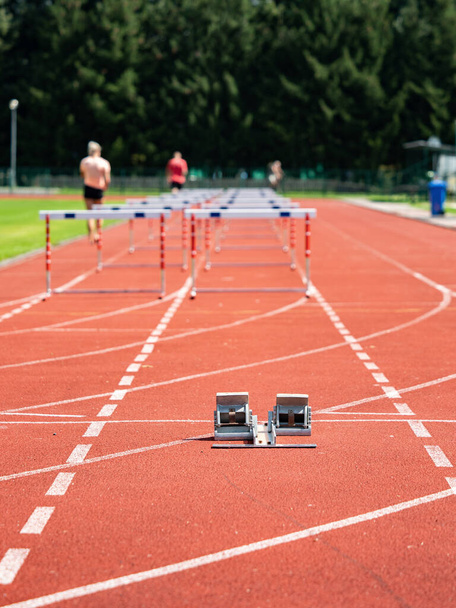 Obstacle course training. Athletics Starting Blocks and red running tracks in a stadion - Photo, Image