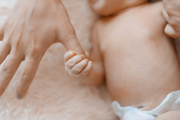 newborn baby holding his moms finger . close-up. - Фото, изображение