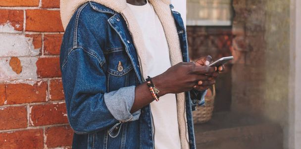Close up of african man with smartphone on city street - Fotó, kép