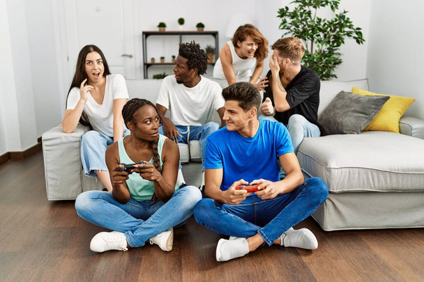 幸せな家庭でビデオゲームを笑っている若い友人のグループ. - 写真・画像