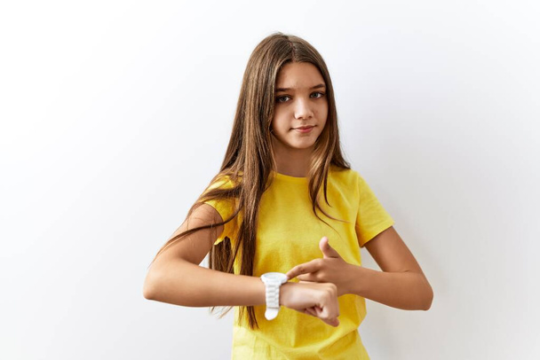 Young brunette teenager standing together over isolated background in hurry pointing to watch time, impatience, upset and angry for deadline delay  - 写真・画像