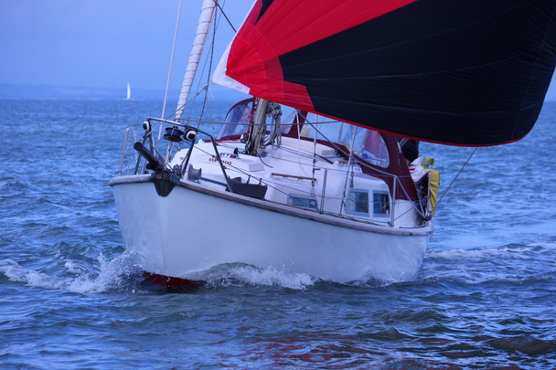 Barca a vela con spinnaker rosso e nero
 - Foto, immagini