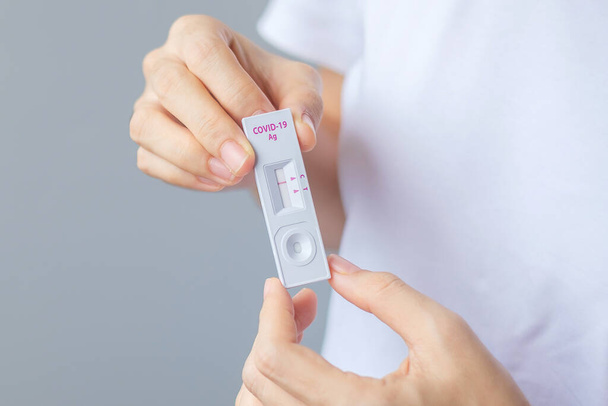 homme tenant un kit de test rapide de l'antigène avec un résultat négatif lors du test COVID-19. Coronavirus Auto-test nasal ou à domicile, Verrouillage et isolement à domicile concept - Photo, image