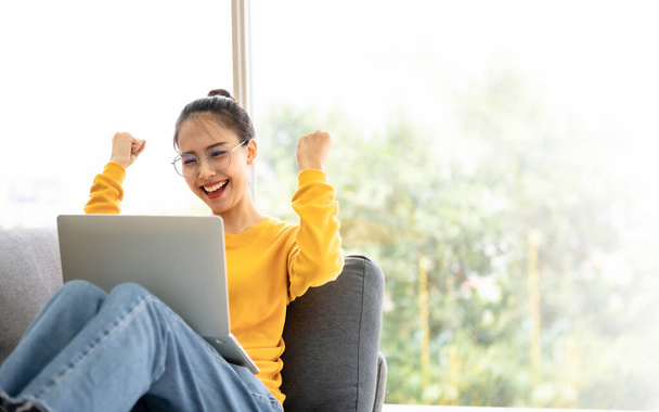Excited female feeling euphoric celebrating online win success achievement result, young asian woman happy about good email news, motivated by great offer or new opportunity - 写真・画像
