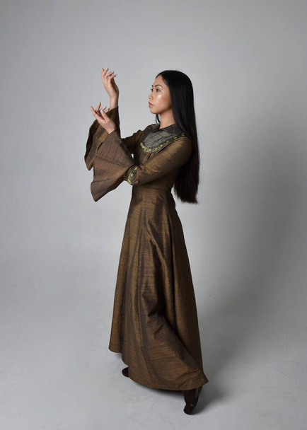 Plná délka portrét krásné mladé asijské ženy s dlouhými vlasy na sobě středověké fantasy šaty kostým. Půvabné stojící pózování izolované na pozadí studia. - Fotografie, Obrázek