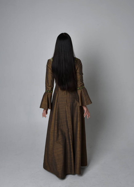 Full length  portrait of beautiful young asian woman with long hair wearing medieval fantasy gown costume. Graceful standing posing walking away,  isolated on studio background. - Фото, изображение
