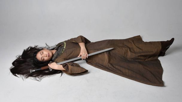 Full length  portrait of beautiful young asian woman with long hair wearing medieval fantasy gown . Graceful sleeping pose,  isolated on studio background. - Photo, Image