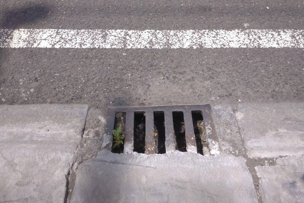 The iron grill covers the drains, as well as being a way for water to flow when it rains so that the road recedes quickly. - Foto, Imagen