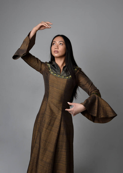 Detail portrét krásné mladé asijské ženy s dlouhými vlasy na sobě středověké fantasy šaty. Půvabná póza s gesturálními rukami, izolovaná na pozadí studia. - Fotografie, Obrázek