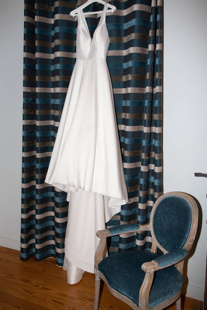 Brautkleid weißes Kleid zu Hause für eine Braut, die im Schlafzimmer hängt - Foto, Bild
